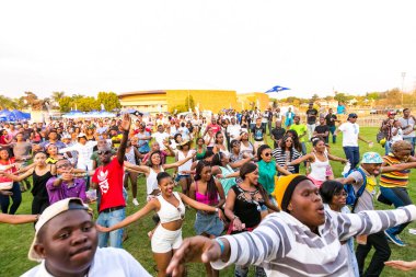 Johannesburg, Güney Afrika 'daki açık hava müzik festivalinde eğlenen bir grup genç.