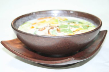 Beyaz arka planda bir kasede taze bir çorba.