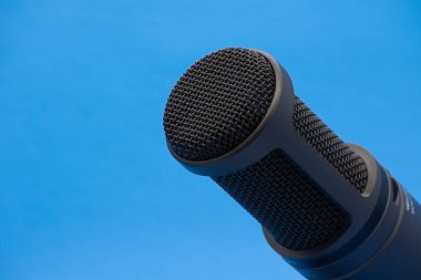İzole edilmiş mavi arkaplanda profesyonel bir podcast mikrofon