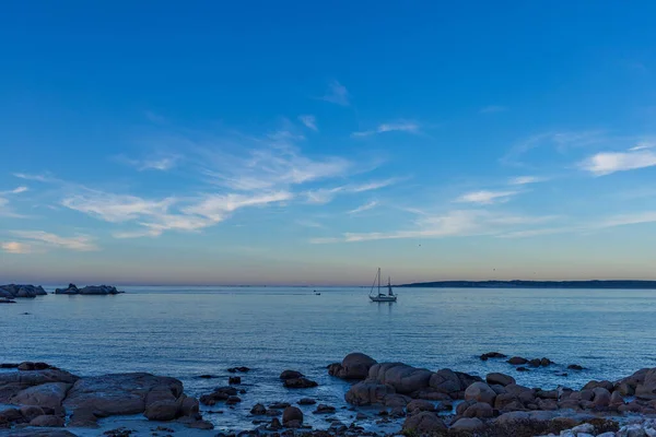 Gün Batımında Sakin Bir Kayalık Denizde Seyreden Bir Teknenin Manzarası — Stok fotoğraf