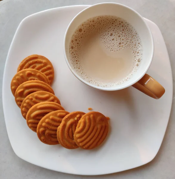 白いプレートにミルクティーとクッキーのカップのトップビュー — ストック写真