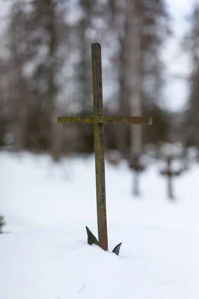 在朦胧的背景下 一个铁十字架被雪夹住的垂直镜头 — 图库照片
