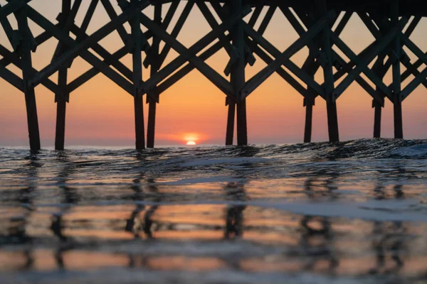 日没時に海の水に木製の港のデザイン — ストック写真
