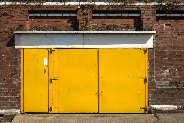 Strzał Żółtych Metalowych Drzwi Ceglanego Budynku — Zdjęcie stockowe