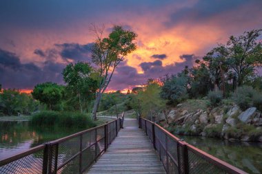 A Beautiful Sunset Colorful and on the wooden bridge at Fain Lake in Prescott Valley, Arizona, USA clipart