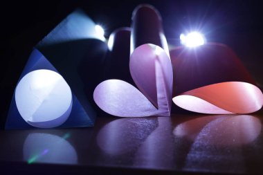 Karanlık bir masanın üzerindeki katlanmış kâğıt formların yakın çekim görüntüsü.