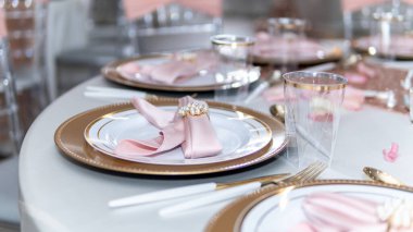 Güzel bir düğün sofrası, pembe ve altın tonlarıyla, mükemmel bir renk kombinasyonu.