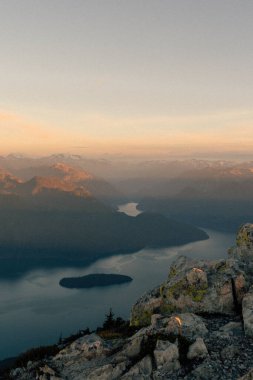 Gün doğumunda nehir boyunca dağların manzaralı bir görüntüsü.