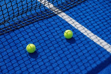 Mavi raket tenis kortunun gölgesinde iki raket tenis topu, raket spor konsepti