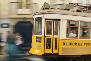Lizbon 'da hareket halindeki eski sarı bir tramvayın yakın çekimi