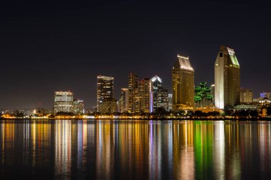 Aydınlatılmış San Diego 'nun güzel bir görüntüsü yansıtıcı suyun yanında gökyüzü.