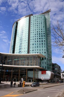 Britanya Kolumbiyası, Kanada 'da güneşli bir günde mavi bulutlu gökyüzüne karşı merkez Surrey alışveriş merkezi ve ofis binasının dikey görüntüsü.