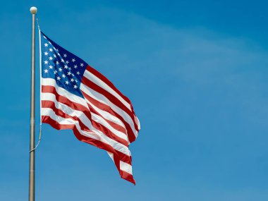 Amerika Birleşik Devletleri bayrağı mavi gökyüzünün arka planında bayrak direğinde