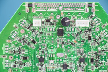 Mavi arka planda elektronik bir ana kartın yakın plan çekimi..