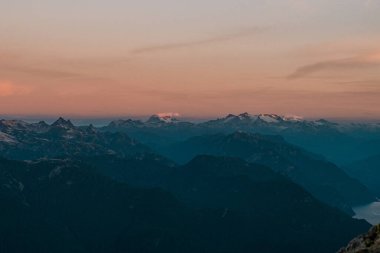 Alacakaranlıkta dağ siluetlerinin manzaralı bir çekimi