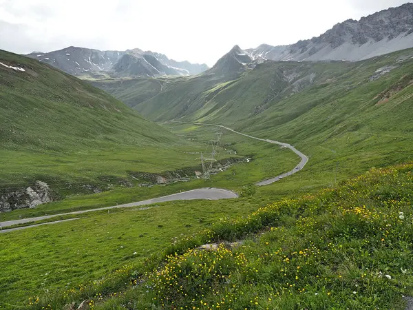 Uma Estrada Que Passa Por Colinas Verdes Montanhas Sob Céu — Fotografia de Stock