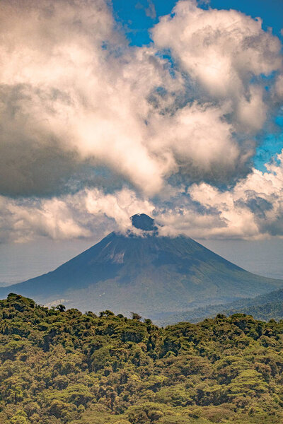 A vertical shot of the Arenal Volcano under the clouds in Costa Rica