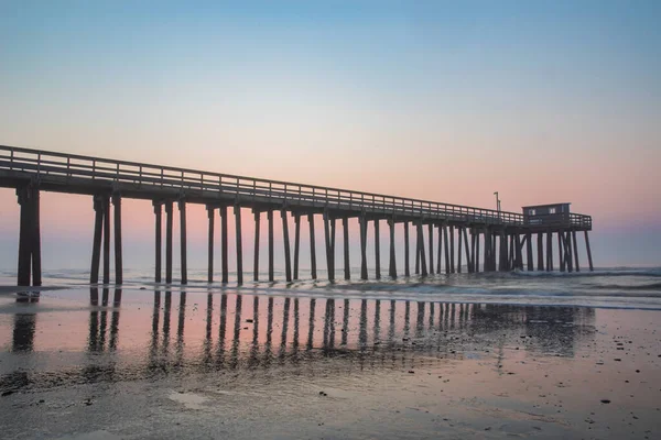 夜明けには砂浜と木製の桟橋の静かな景色 — ストック写真