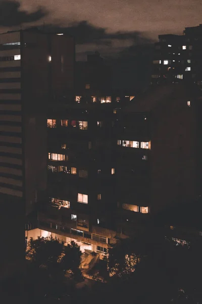 Вертикальний Знімок Багатоповерхових Будівель Вночі Кількома Освітленими Вікнами — стокове фото