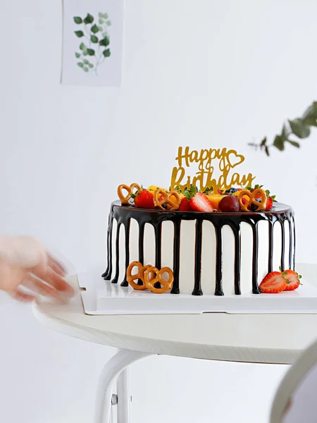 白い背景の白いテーブルの上にチョコレートシロップ 幸せな誕生日サインのケーキ — ストック写真