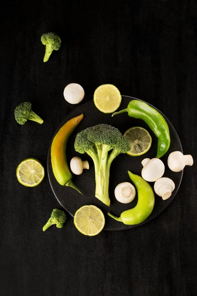 Een Verticaal Shot Broccoli Met Champignons Een Zwarte Plaat — Stockfoto