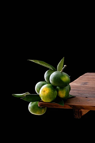 Vertical Shot Green Tangerines Wooden Table Isolated Black Background — Stock Photo, Image