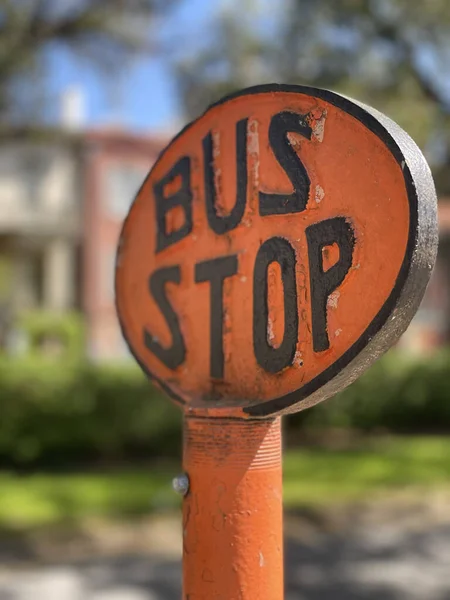 Vertikale Aufnahme Eines Orangefarbenen Runden Bushaltestellenschildes Mit Schwarzen Buchstaben — Stockfoto