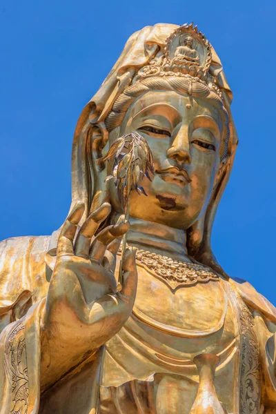Pionowe Zbliżenie Strzału Złotego Posągu Buddy Przeciw Jasnemu Bezchmurnemu Niebu — Zdjęcie stockowe