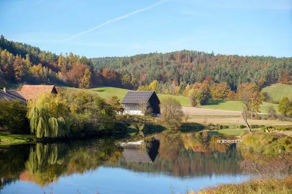 秋の木々に囲まれた湖の近くの小さな家の空中風景 — ストック写真