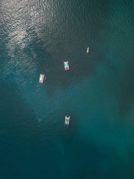 A top view of boats floating in the turquoise sea