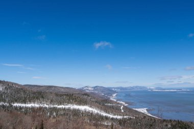 Kışın dağların yanında güzel bir deniz manzarası.