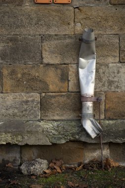 Kırık bir metalik borunun dikey görüntüsü binaya yağmur suyu yağdırmak için yapılmış.