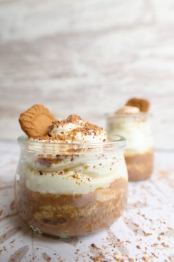 Bulanık arka planda krema, şeker ve kakaodan yapılmış bir kahvenin dikey çekimi.