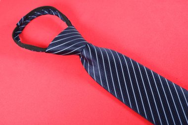 Kırmızı arka planda izole edilmiş çizgili bir kravat.