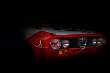 A closeup shot of an old red Alfa Romeo Junior Reply GTA racing car with black background in Pesaro, Italy clipart