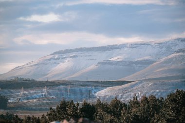Güney Afrika, Matroosberg 'de bulutlu gri bir gökyüzünün altındaki karlı dağların yakınındaki kayalık kayalıkların güzel manzarası.