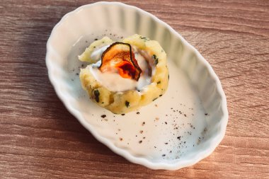 Beyaz oval tabaktaki güzel dekore edilmiş bir tabağın yakın çekimi.