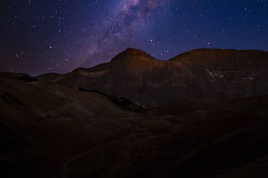 Samanyolu galaksisi geceleri Teide Dağı 'nın karanlık siluetinin üzerinde döner..