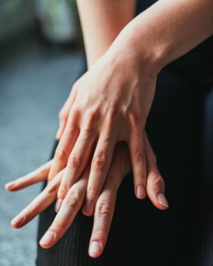 Bir kadının kucağındaki elinin dikey görüntüsü.