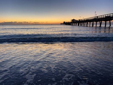 Florida 'nın doğu kıyısında bir balıkçı iskelesi ile Atlantik Okyanusu' nda gün doğumu