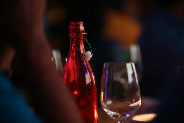 Primer Plano Una Botella Vidrio Rojo Una Copa Vino Sobre —  Fotos de Stock