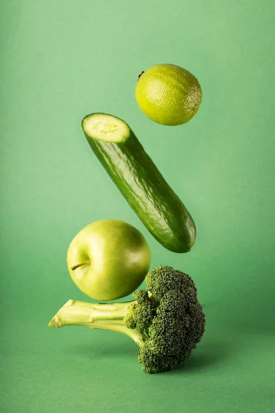 Een Verticaal Shot Van Drijvende Gezonde Groenten Appel Geïsoleerd Groene — Stockfoto
