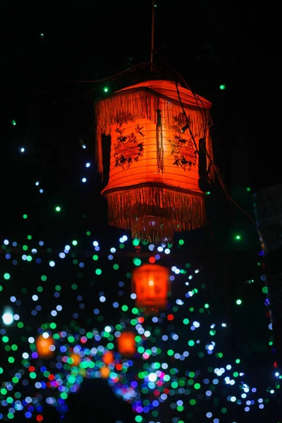 A vertical shot of flying lantern in dark sky during lantern festival in bokeh background