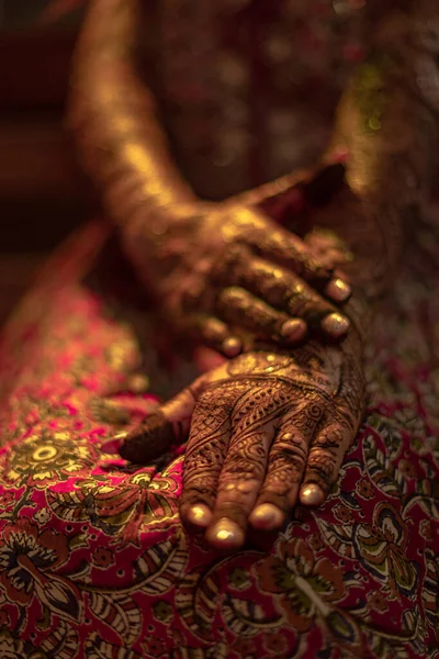 A vertical closeup hands in henna