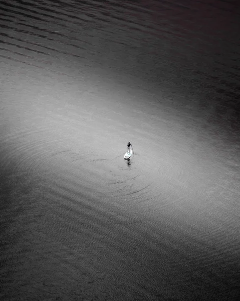Вертикальный Снимок Мужчины Стоящего Доске Серфинга Спокойной Воде — стоковое фото