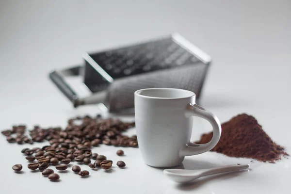 背景に大きなコーヒー豆と粉末と白のコーヒーマグカップの浅い焦点 — ストック写真
