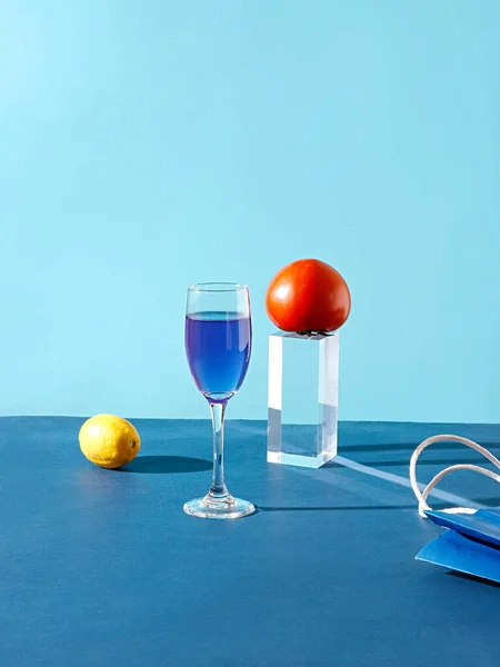 Een Glas Blauwe Vloeistof Citroen Tomaat Een Stuk Glas Een — Stockfoto