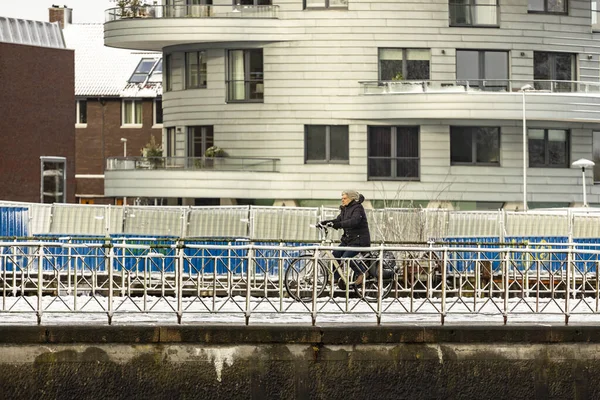 Kvinna Rida Cykel Snöig Kaj Med Moderna Moderna Bostadstorn Bakgrunden — Stockfoto