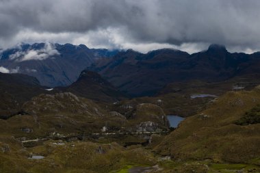 Bulutlu bir gökyüzünün altındaki engin dağ manzarasının doğal görüntüsü.