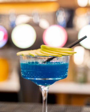 Armut dilimli mavi bir kokteylin dikey yakın çekimi.